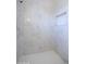 Marble tiled shower stall with built-in niche and white tiled floor at 3547 W Encanto Blvd, Phoenix, AZ 85009