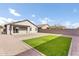 Backyard featuring low-maintenance landscaping with gravel, artificial grass, and a patio at 36852 N Yellowstone Dr, San Tan Valley, AZ 85140