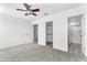 Bright bedroom with neutral carpet, white walls, ceiling fan, closet, and en-suite bathroom at 36852 N Yellowstone Dr, San Tan Valley, AZ 85140