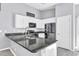 Contemporary kitchen featuring white cabinetry, granite counters, and a black appliance suite at 36852 N Yellowstone Dr, San Tan Valley, AZ 85140