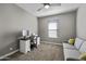 This bedroom includes a desk, grey colored sofa, and a ceiling fan at 38162 W Santa Monica Ave, Maricopa, AZ 85138