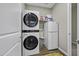 A laundry room features a stacked washer/dryer and a compact refrigerator for added convenience at 38162 W Santa Monica Ave, Maricopa, AZ 85138