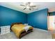 Cozy bedroom featuring a striking blue accent wall and soft carpet at 40176 W Williams Way, Maricopa, AZ 85138