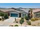 Charming single-story home with a well-manicured front yard and a blue garage door at 40176 W Williams Way, Maricopa, AZ 85138