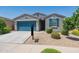 Charming single-story home with a well-manicured front yard and inviting blue garage door at 40176 W Williams Way, Maricopa, AZ 85138