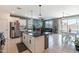 Open floor plan featuring a kitchen island, adjacent living room, dining area, and sliding door to the backyard at 40176 W Williams Way, Maricopa, AZ 85138