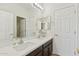 Bright bathroom featuring double sinks with a large mirror, and a doorway leading to the shower and toilet at 4043 W Aire Libre Ave, Phoenix, AZ 85053