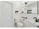 Bright bathroom with white fixtures, including toilet, sink, and large mirror at 4043 W Aire Libre Ave, Phoenix, AZ 85053