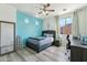 Stylish bedroom featuring blue accent wall, wood-look floors, and modern decor at 4043 W Aire Libre Ave, Phoenix, AZ 85053