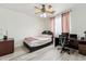 Bedroom with ceiling fan, wood-look floors, and a desk workspace at 4043 W Aire Libre Ave, Phoenix, AZ 85053