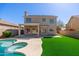 Stunning backyard featuring a sparkling pool, lush artificial turf, and covered patio perfect for outdoor entertaining at 4216 E Tether Trl, Phoenix, AZ 85050