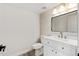 Half bathroom featuring a single sink vanity, decorative mirror, and wood-look flooring at 4216 E Tether Trl, Phoenix, AZ 85050