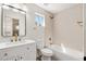 Bathroom features a single sink vanity with decorative mirror, shower-tub combo, and wood-look flooring at 4216 E Tether Trl, Phoenix, AZ 85050