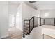 Hallway with modern black metal banister, neutral paint, and wood-look flooring at 4216 E Tether Trl, Phoenix, AZ 85050