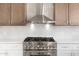 A stainless steel range and hood stand out against the white tile backsplash and bright cabinetry at 4216 E Tether Trl, Phoenix, AZ 85050