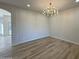 Open living room with modern chandelier, wood-look tile flooring, and neutral paint at 4216 E Tether Trl, Phoenix, AZ 85050