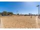 A sand volleyball court at a park with trees, walking path, and playground in the background at 4216 E Tether Trl, Phoenix, AZ 85050