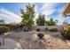 Landscaped backyard with a gravel surface, fire pit area, and comfortable seating, creating a peaceful outdoor space at 4409 E Gelding Dr, Phoenix, AZ 85032