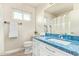 Bathroom with a blue countertop, white cabinets, and a large mirror at 4409 E Gelding Dr, Phoenix, AZ 85032