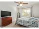 Bedroom with a ceiling fan, window, and a dresser with a TV at 4409 E Gelding Dr, Phoenix, AZ 85032