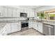 Bright kitchen featuring white cabinetry, modern appliances, and wood-look floors at 4409 E Gelding Dr, Phoenix, AZ 85032