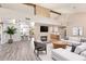 Bright living room featuring a fireplace with mounted TV and an open floorplan with a view to the kitchen at 4409 E Gelding Dr, Phoenix, AZ 85032
