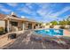 Backyard view of a pristine pool with a covered patio, BBQ area, and comfortable seating, perfect for enjoying sunny days at 4409 E Gelding Dr, Phoenix, AZ 85032