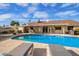 Inviting backyard pool and covered patio, perfect for outdoor relaxation and entertaining with patio furniture and landscaping at 4409 E Gelding Dr, Phoenix, AZ 85032