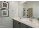 Modern bathroom with a double sink vanity, gray cabinets, and decorative artwork on the wall at 6451 N 17Th Pl, Phoenix, AZ 85016