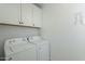 Laundry room with white washer and dryer, overhead cabinets, and a wire rack at 6451 N 17Th Pl, Phoenix, AZ 85016