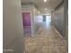 A bright hallway with recessed lighting, tile floors, and neutral walls leads to the main living areas at 7321 N 123Rd Dr, Glendale, AZ 85307