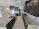 A spacious kitchen featuring granite countertops, an island with a sink, and dark wood cabinetry at 7321 N 123Rd Dr, Glendale, AZ 85307