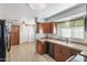 Bright kitchen featuring wood cabinets, neutral countertops, tile floors, and a stainless steel dishwasher at 734 S Edgewater Dr, Mesa, AZ 85208