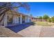 Backyard featuring a covered patio, brick pavers, desert landscaping, and grassy areas at 792 W Nolan Way, Chandler, AZ 85248