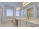 Bright bathroom with a double sink vanity, a large mirror, a soaking tub, and natural light from the window at 792 W Nolan Way, Chandler, AZ 85248