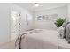 Bedroom with adjacent bathroom and comfortable bed with natural light from louvered windows at 800 W Erie St, Chandler, AZ 85225