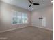 Bright bedroom boasts a ceiling fan, carpet, and shuttered windows, with a TV mount on the wall at 8180 W Silver Spring Way, Florence, AZ 85132