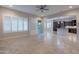 Open layout view of the living room with sliding doors to a patio, plantation shutters and the kitchen at 8180 W Silver Spring Way, Florence, AZ 85132