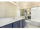 Bright bathroom featuring a vanity with grey cabinets and a combination shower and tub at 819 W Kyle E Ct, Gilbert, AZ 85233