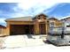 New construction shows the home's frame with roofing tiles and a spacious two-car garage ready to be finished at 8452 W Clemente Way, Florence, AZ 85132