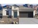 Single-story home featuring a two-car garage and desert landscaping with a mountain view at 8452 W Clemente Way, Florence, AZ 85132