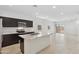 Open-concept kitchen with stainless steel appliances, marble island, and adjacent living space creates a seamless flow at 8452 W Clemente Way, Florence, AZ 85132