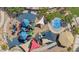 Aerial view of a colorful playground with shaded seating, play structures, and water splash pad at 8452 W Clemente Way, Florence, AZ 85132