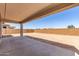 Covered back patio with a concrete slab and view of the backyard enclosed by a brick wall at 8553 N 175Th Ln, Waddell, AZ 85355