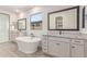 Luxurious bathroom with a freestanding tub, double vanities with granite countertops, and a glass-enclosed shower at 8553 N 175Th Ln, Waddell, AZ 85355