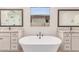 Bright bathroom featuring a soaking tub, dual vanities with granite countertops, and modern fixtures at 8553 N 175Th Ln, Waddell, AZ 85355