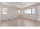 Bright bedroom with wood-look tile flooring, a ceiling fan, and multiple windows at 8553 N 175Th Ln, Waddell, AZ 85355
