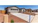A view of the front of the house with desert landscaping and a two car garage at 8553 N 175Th Ln, Waddell, AZ 85355
