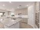 Open kitchen with granite countertops, stainless appliances, a large island, and white cabinets at 8553 N 175Th Ln, Waddell, AZ 85355