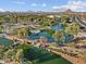 A picturesque aerial view shows a scenic lake, bridge, and landscaped park in a community at 8554 W Trenton Ct, Florence, AZ 85132